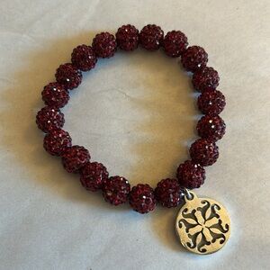NWOT stretch bracelet with dark red sparkly beads, silver tone metal pendant